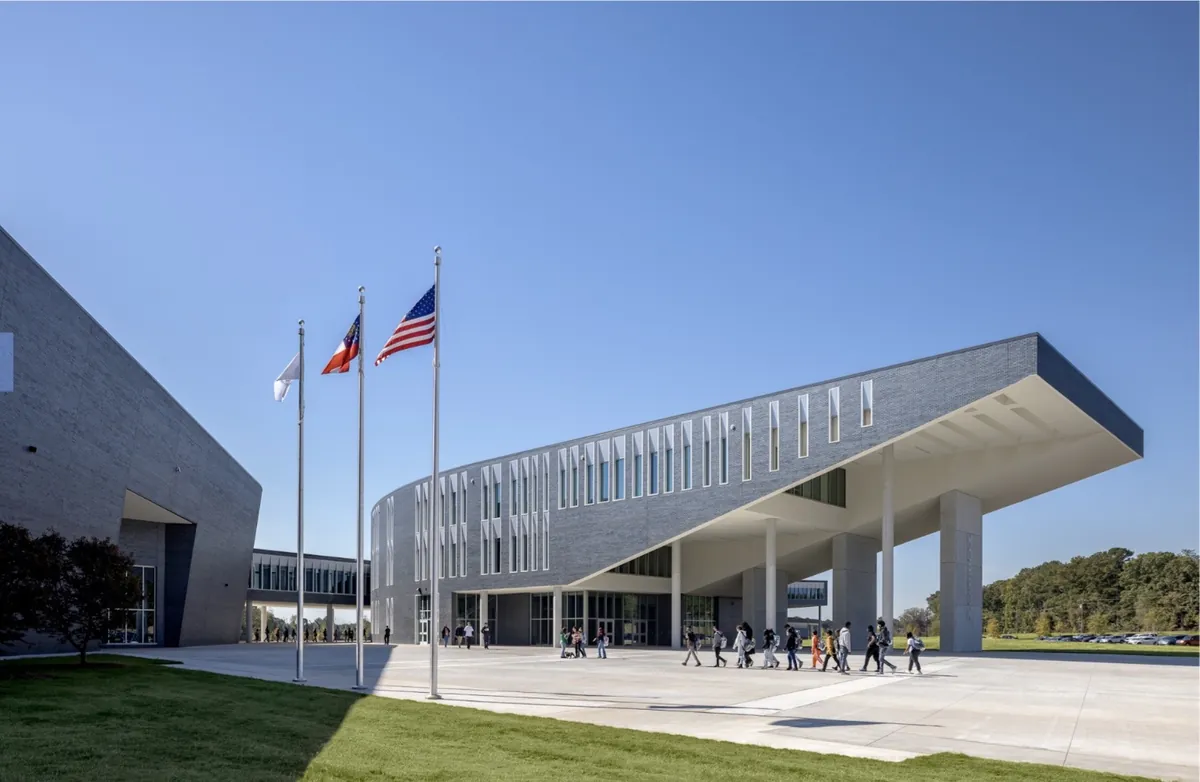Morrow High School entrance with flagpoles and a cantilevered canopy
